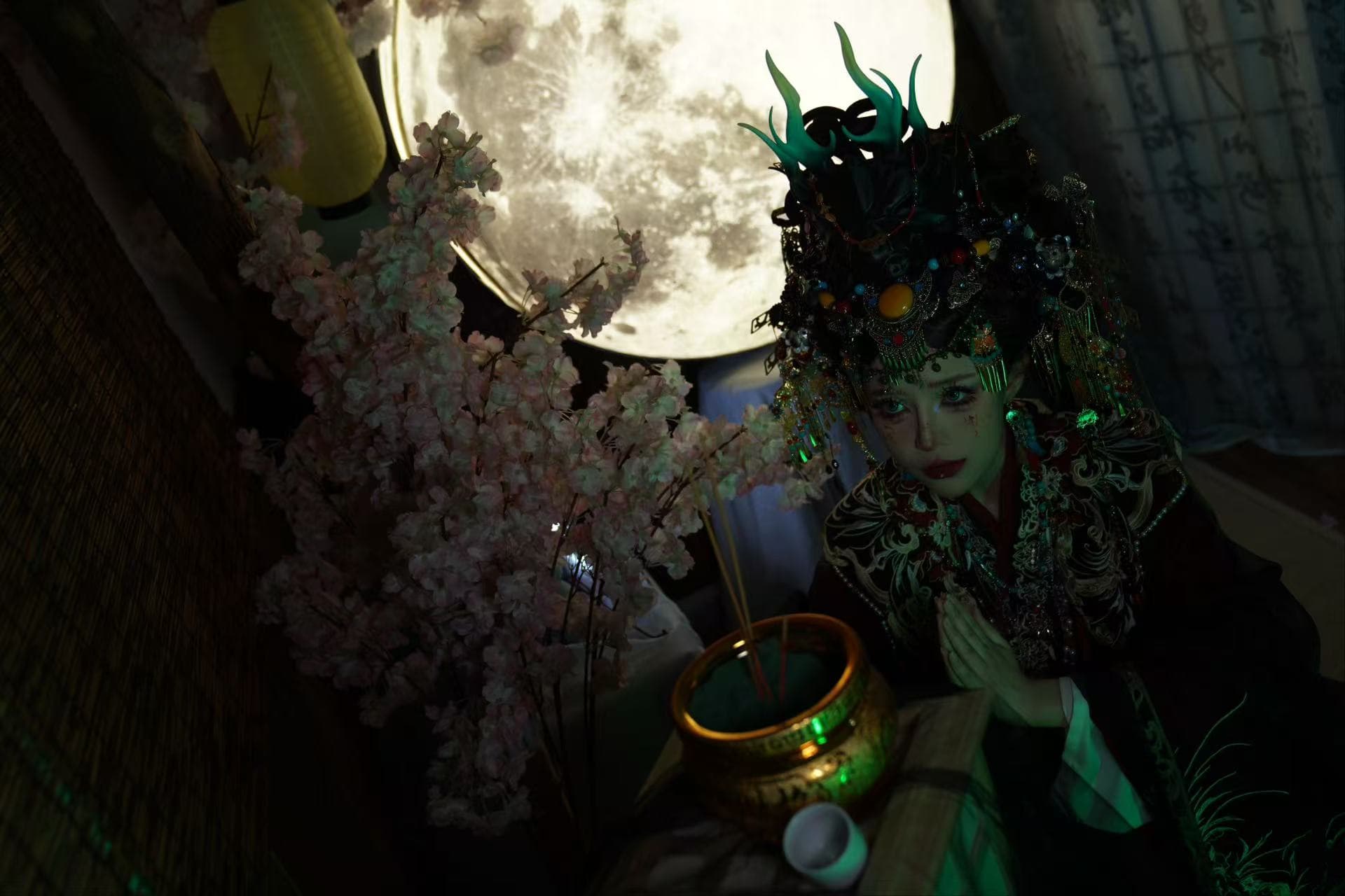 The practitioner in ceremonial dress beneath a full moon
